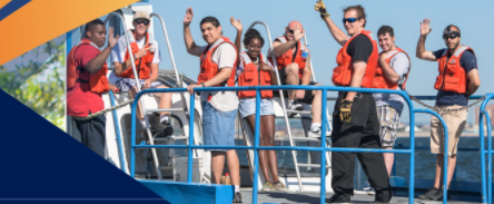 Photo of KCC students waving on a boat